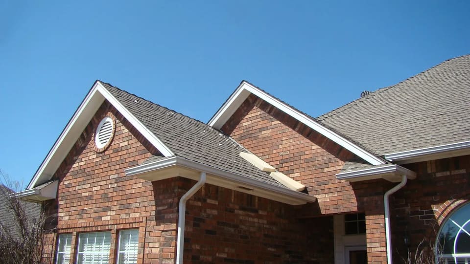 A brick home in Bethany, OK with freshly painted white eaves and fascia