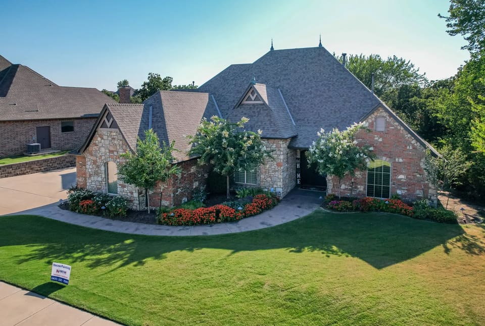Large stone and brick home on Lakeshire Ridge Road in Edmond, OK after an exterior repaint by Hometown Painting
