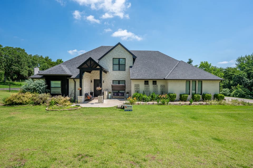 White painted brick and stucco home with black trim on Lost Forest Drive in Edmond, OK