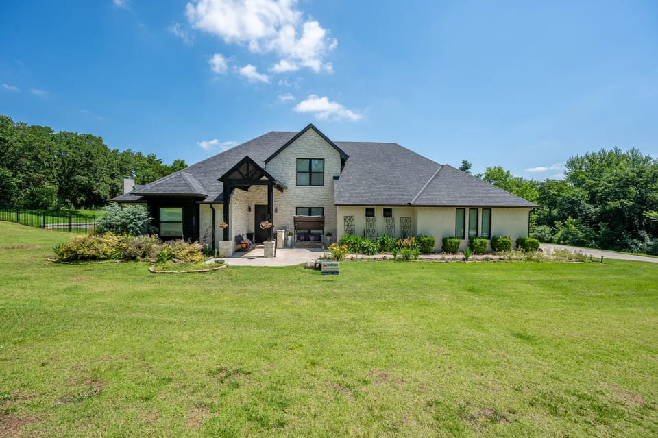 White painted brick and stucco home with black trim on Lost Forest Drive in Edmond