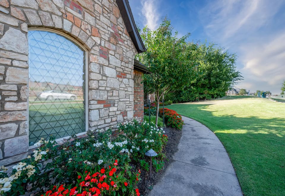 Close detail of stone, trim, and an arched window on an Edmond, OK home