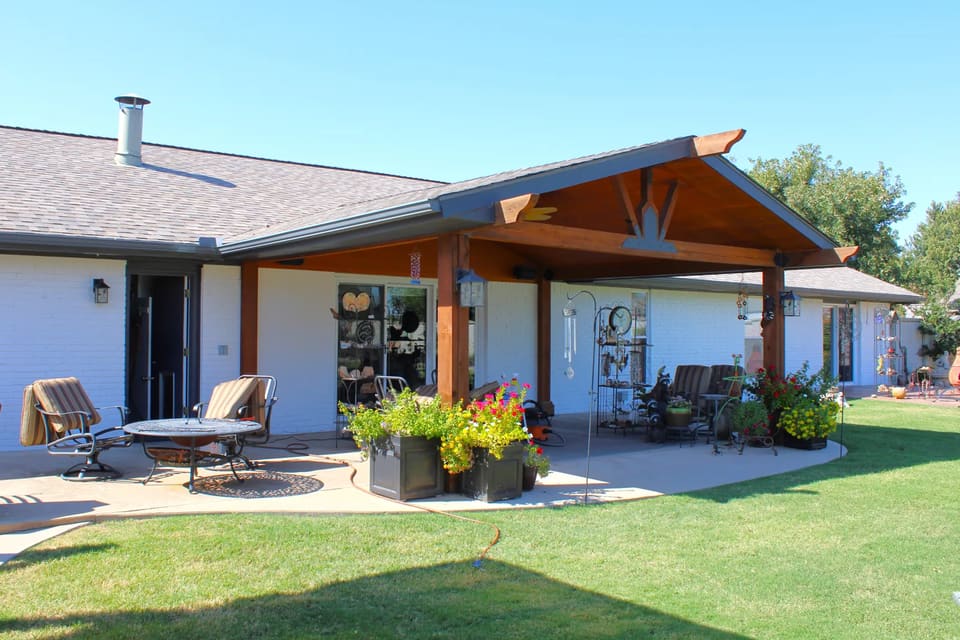 Painted white brick home in Mustang, OK with a stained timber patio cover