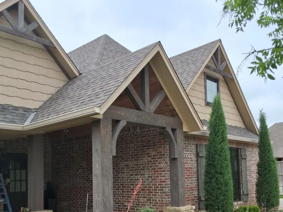 Craftsman brick home in Yukon with restained timber porch beams, repaint in progress