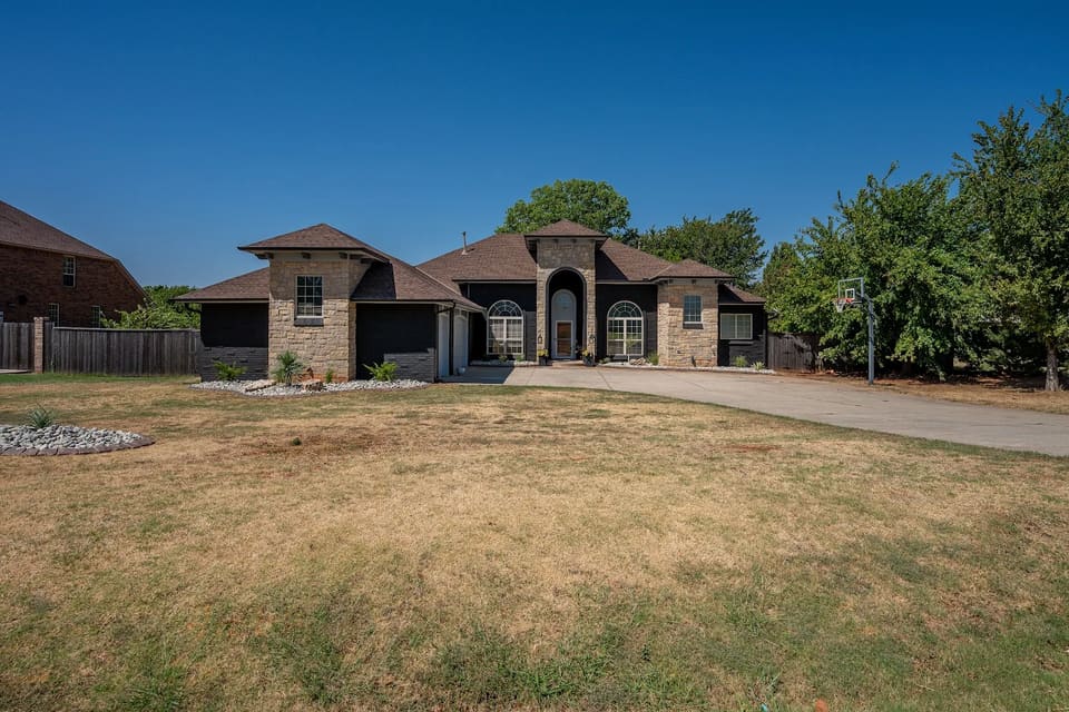Stone and brick home in Edmond with the brick painted charcoal black by Hometown Painting