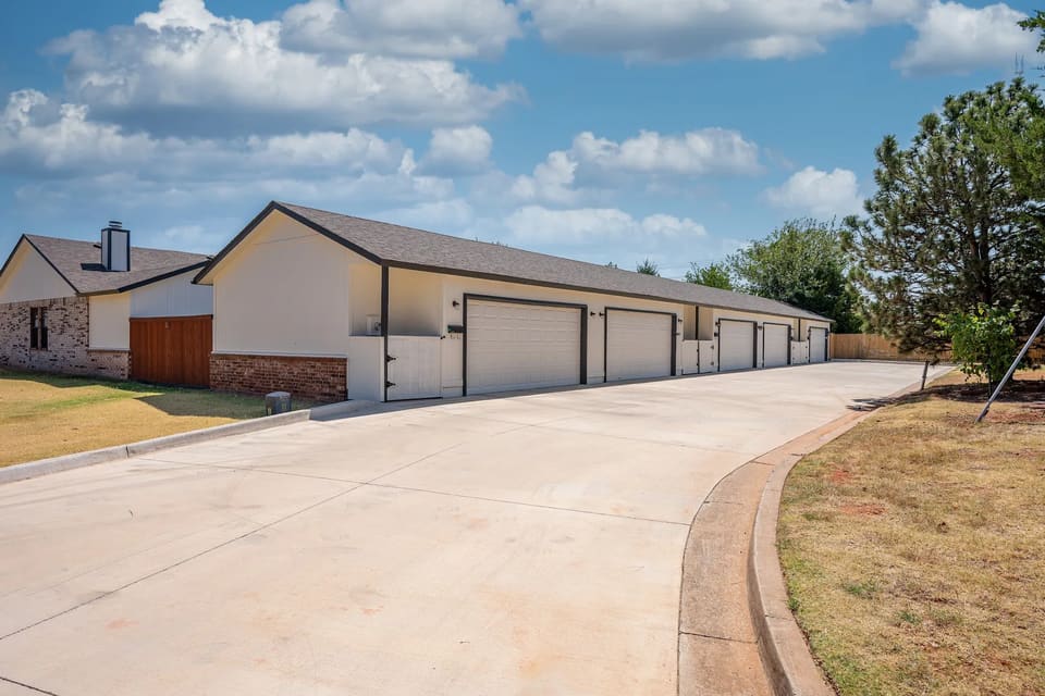 Long garage row at The Crossing in Edmond, OK with freshly painted doors, siding, and fascia