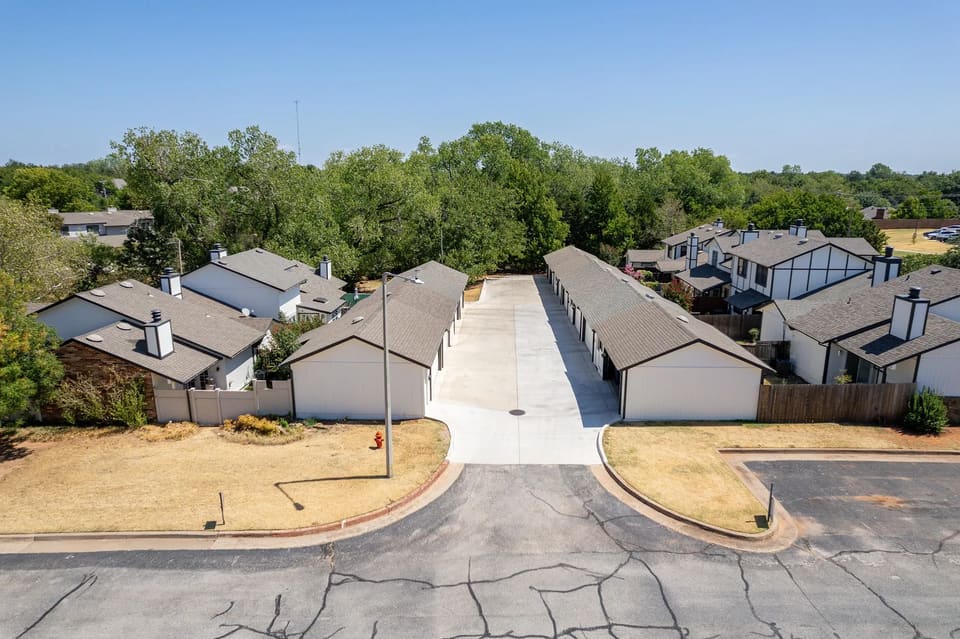 Aerial view of a freshly painted garage court at The Crossing in Edmond, OK with off-white garage doors and dark fascia